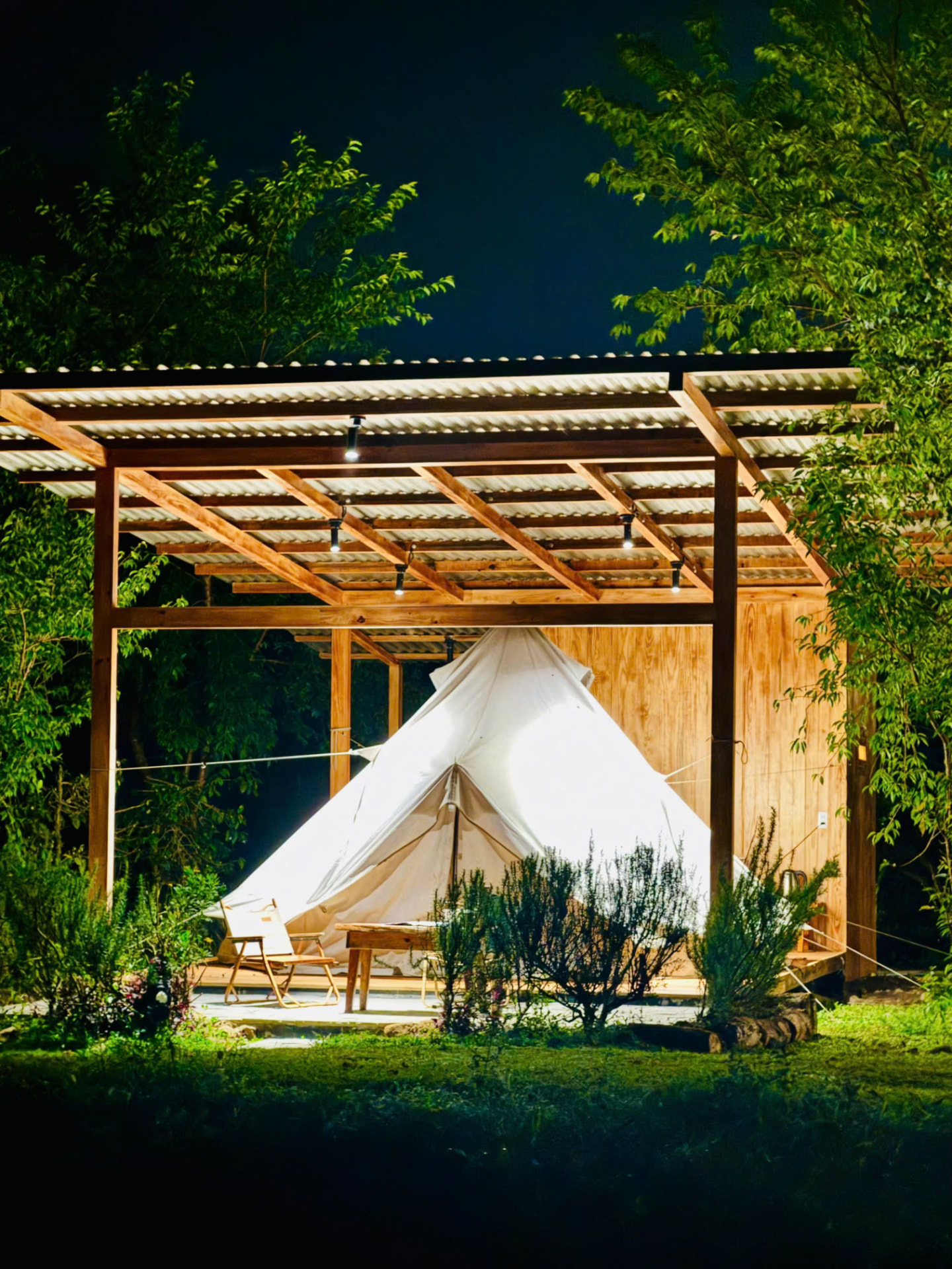Lều glamping dưới mái gỗ trong đêm